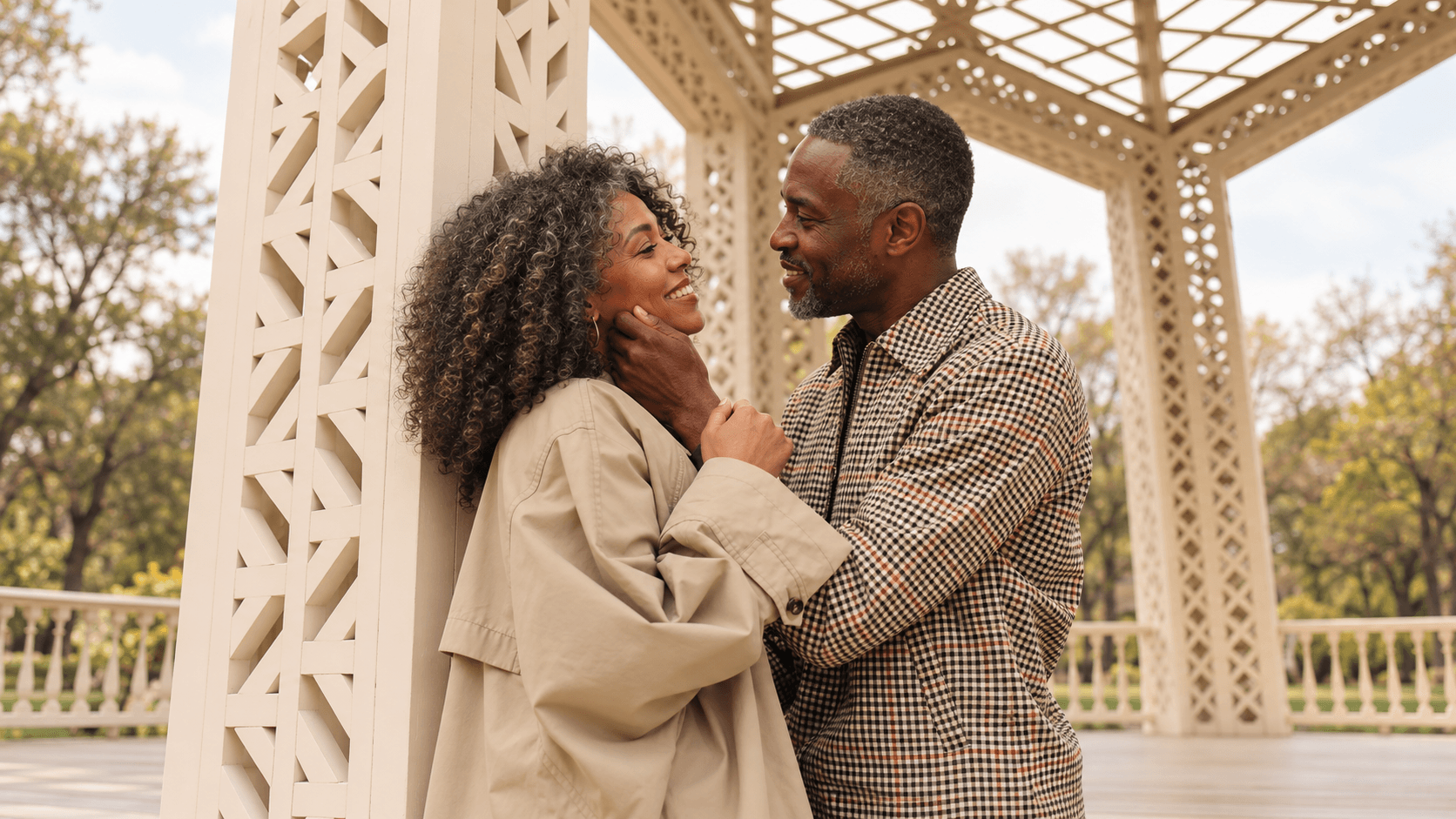 An older Black couple smiling at each other in a white gazebo